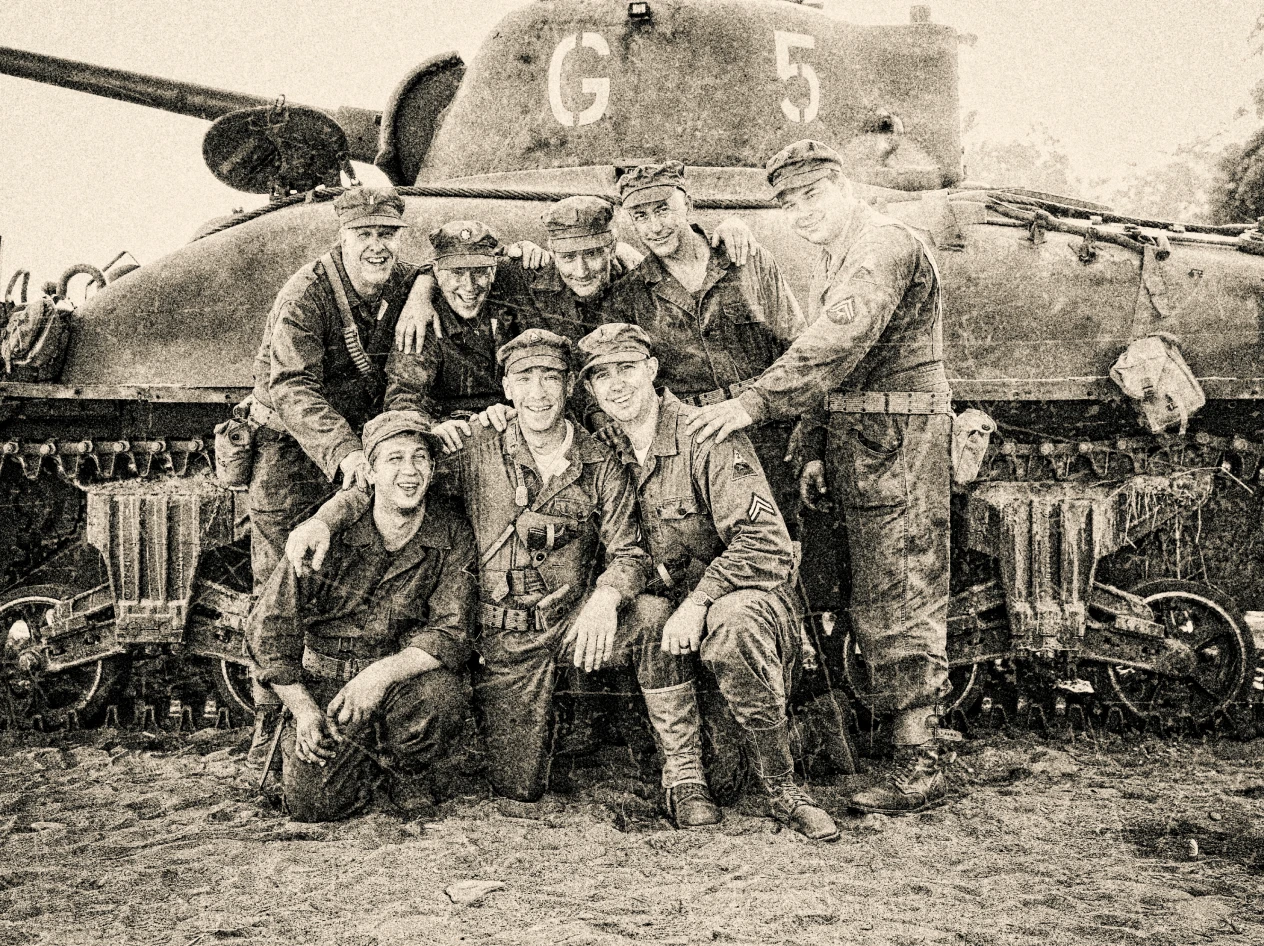 Soldiers posing in front of a tank