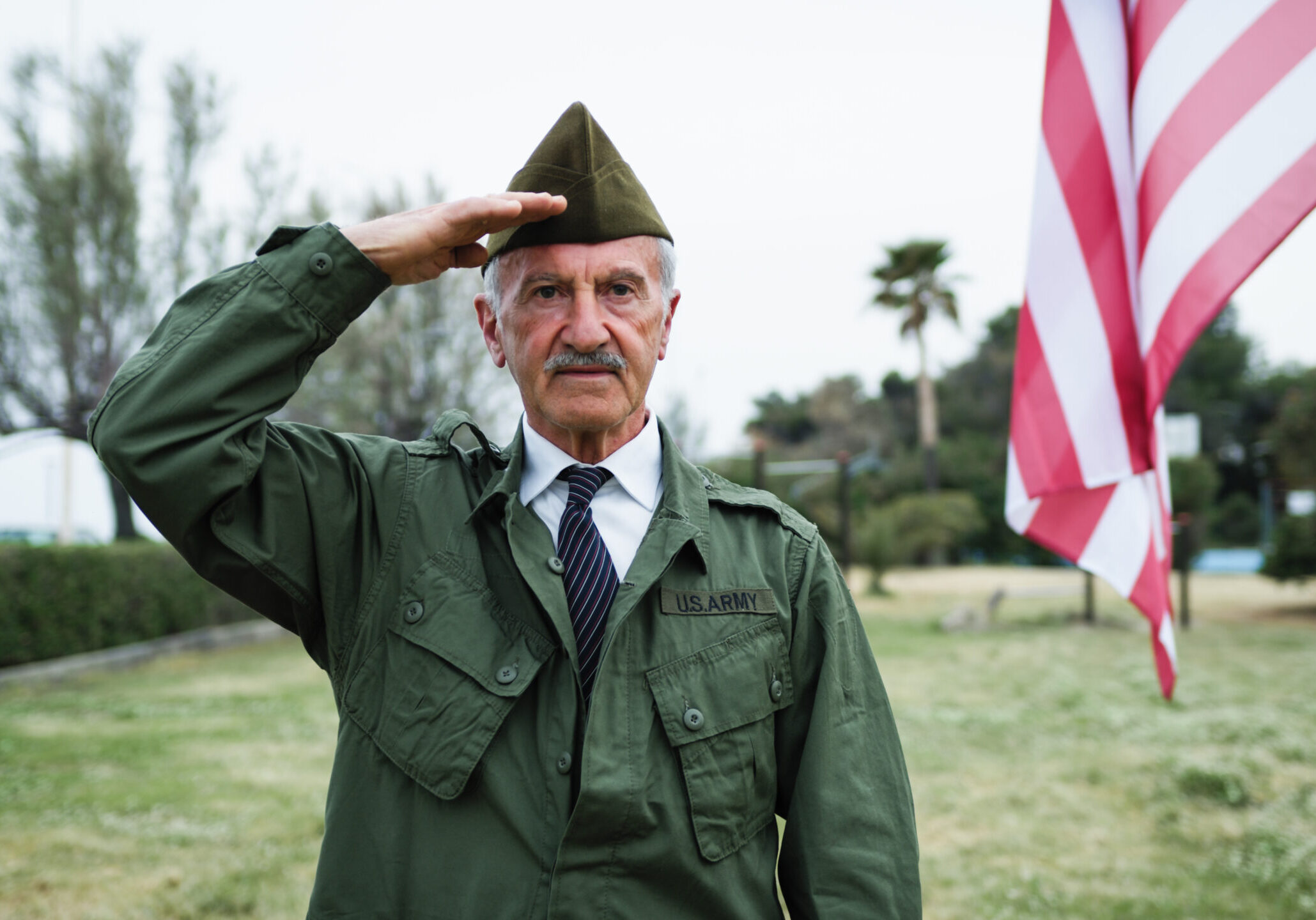 Man in uniform saluting outdoors